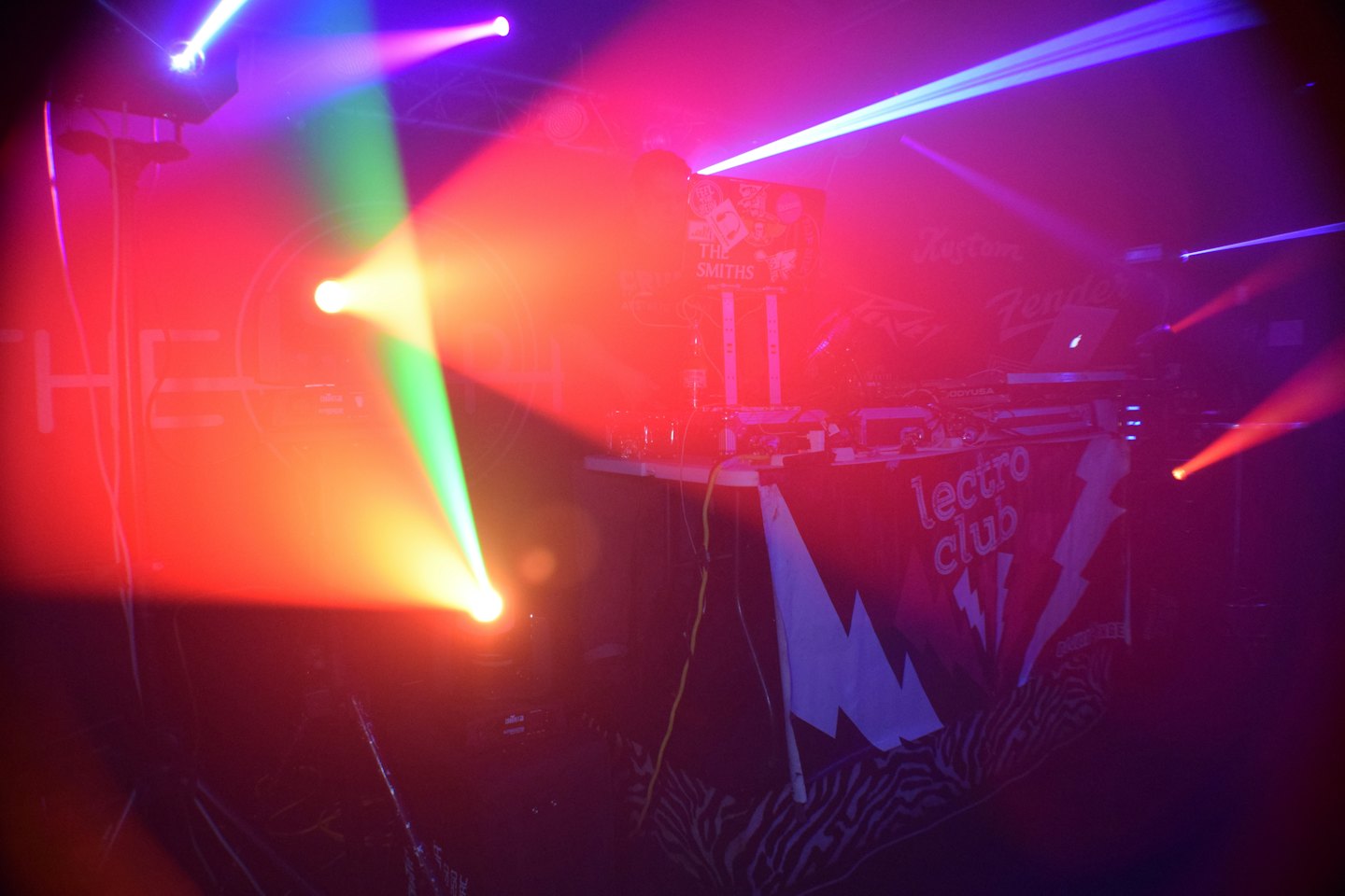 DJ-Ausrüstung und Laptop auf einem Tisch in einem Club.